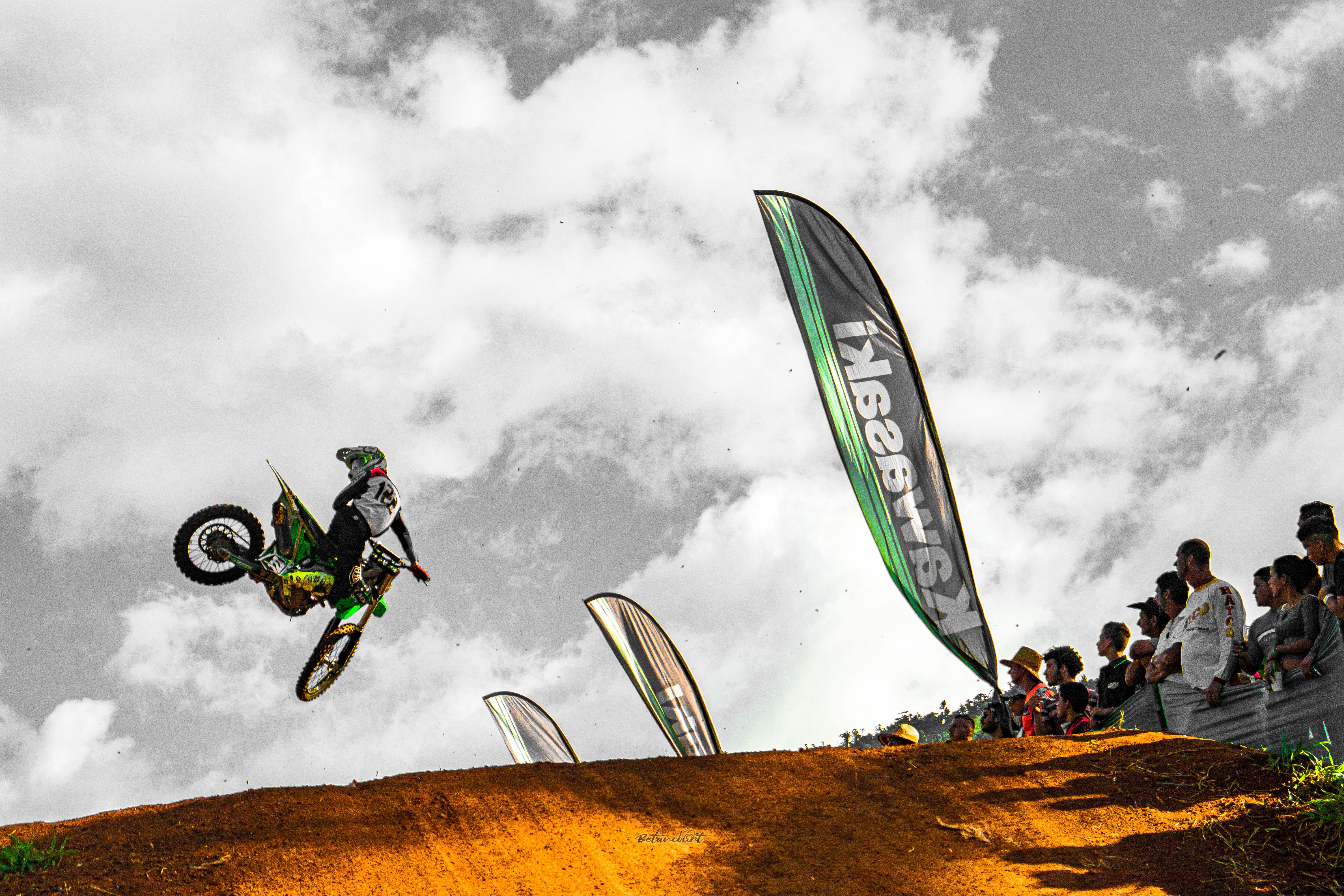 Piloto de motocross saltando sobre la pista con el público de fondo, Costa Rica