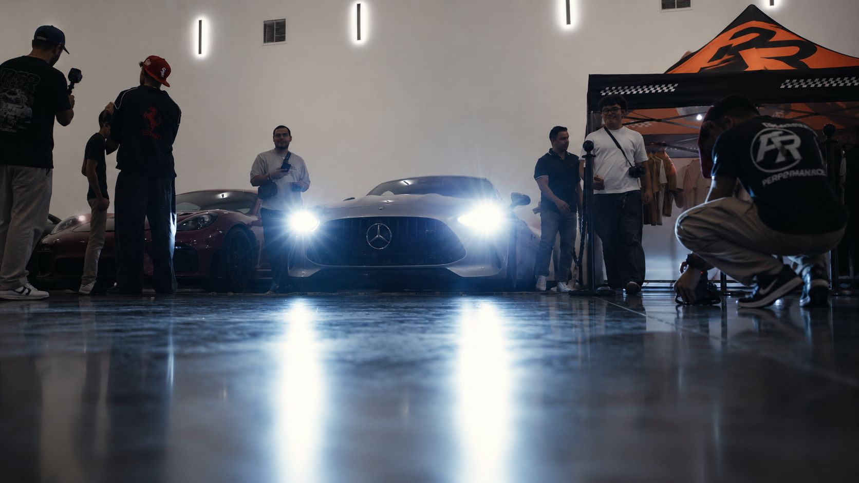 Mercedes-AMG GT de frente con los faros encendidos en un taller, en blanco y negro