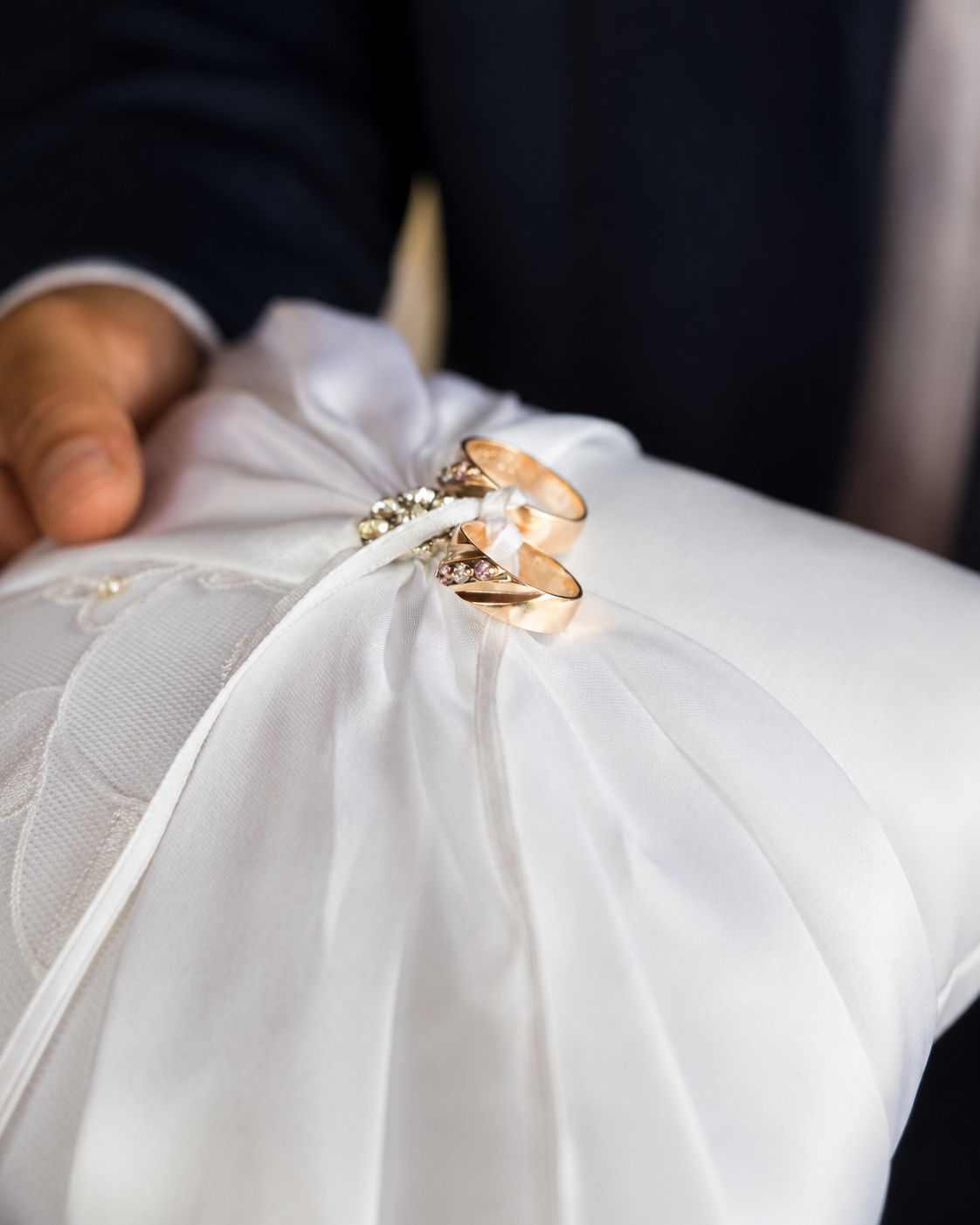 Detalle de los anillos de boda sobre un cojín blanco, sostenido en la ceremonia
