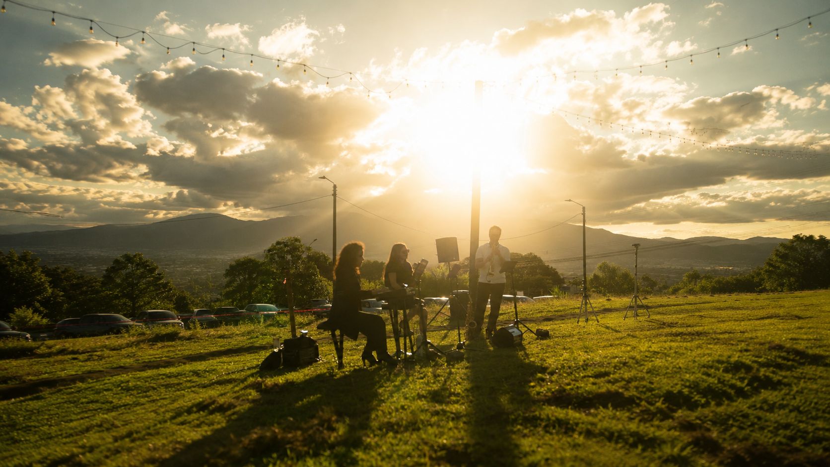Siluetas de un grupo de personas a contraluz en un mirador del Valle Central al atardecer