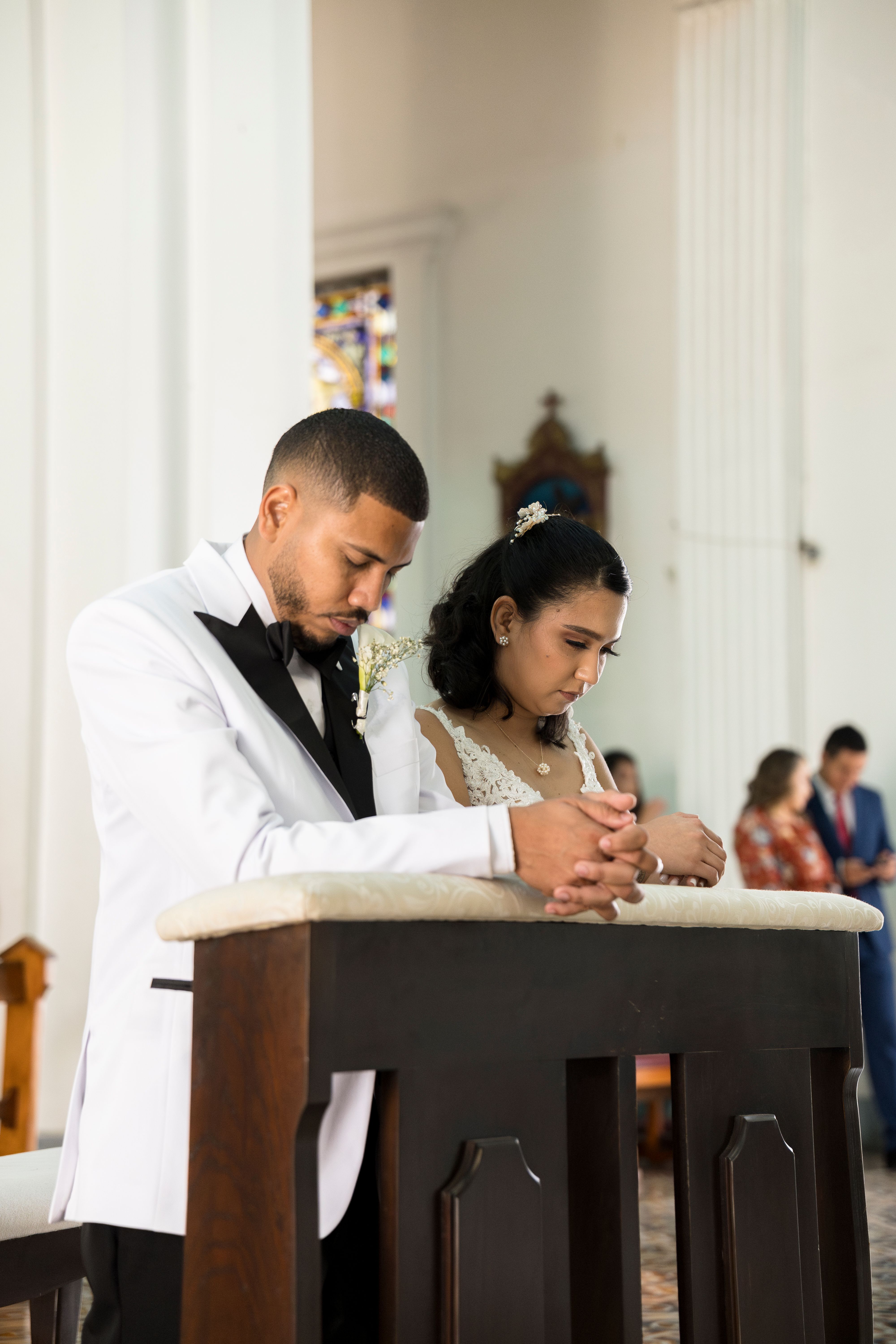 Esposo y esposa hincados al altar en boda
